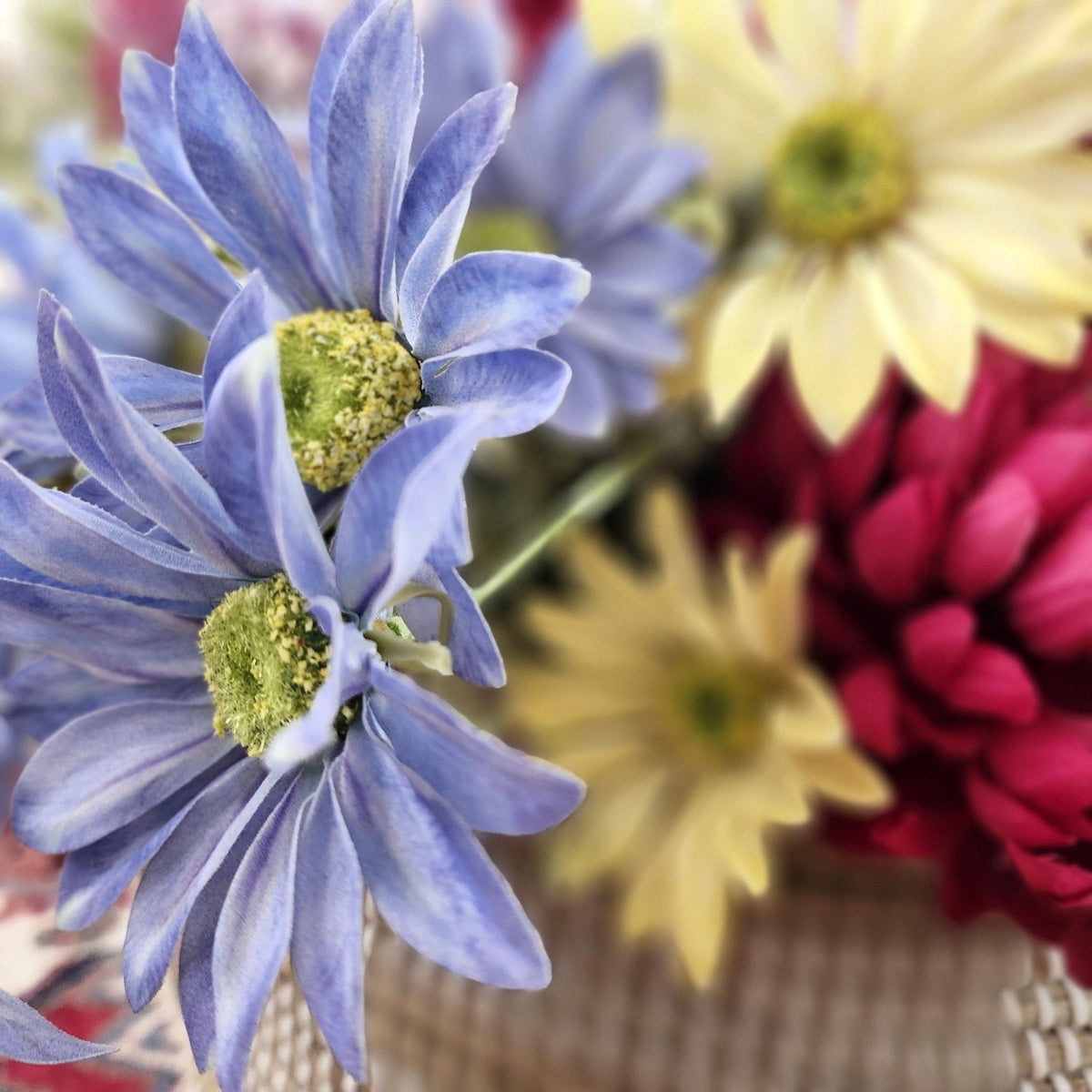Artificial marguerite daisy in blue, one of the four shades made alongside yellow, white and pink as well