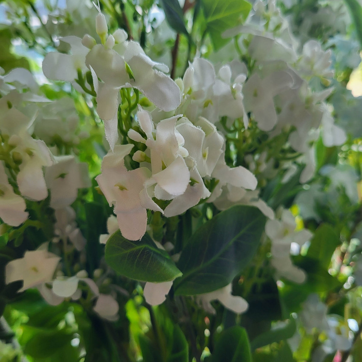 Artificial jasmine in white, delicate lifelike blooms that need no water and last far beyond a season