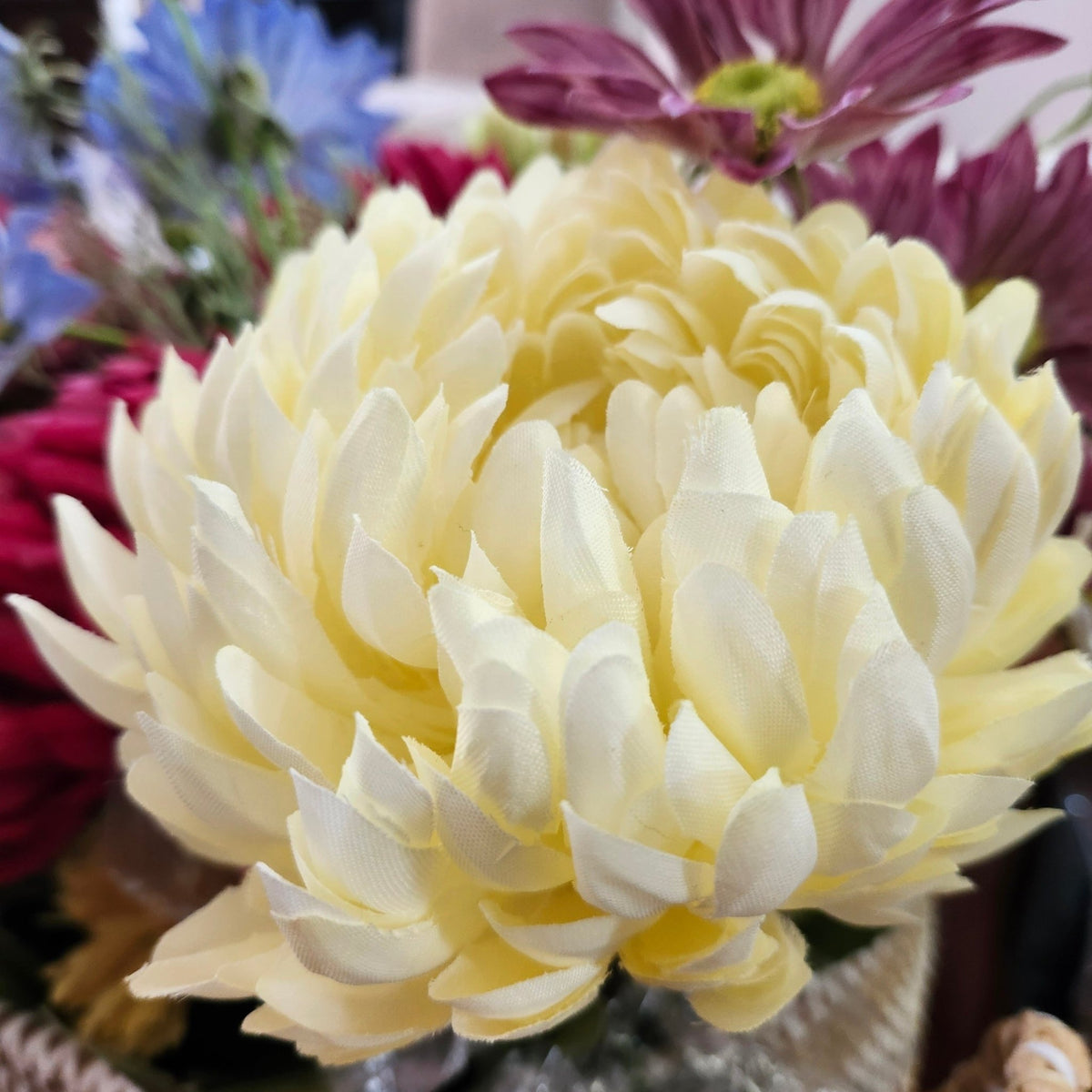 Close view of the cream artificial peony, its layered petals close to those of a real garden bloom in summer