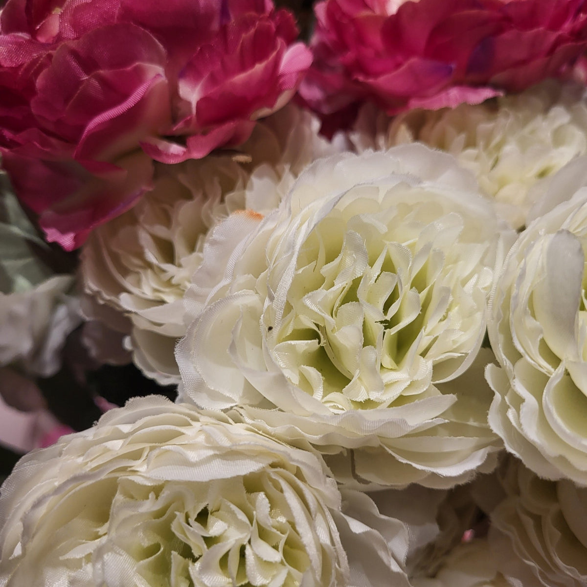 Artificial ranunculus stem seen from another angle, with two open Persian buttercup flowers and a bud
