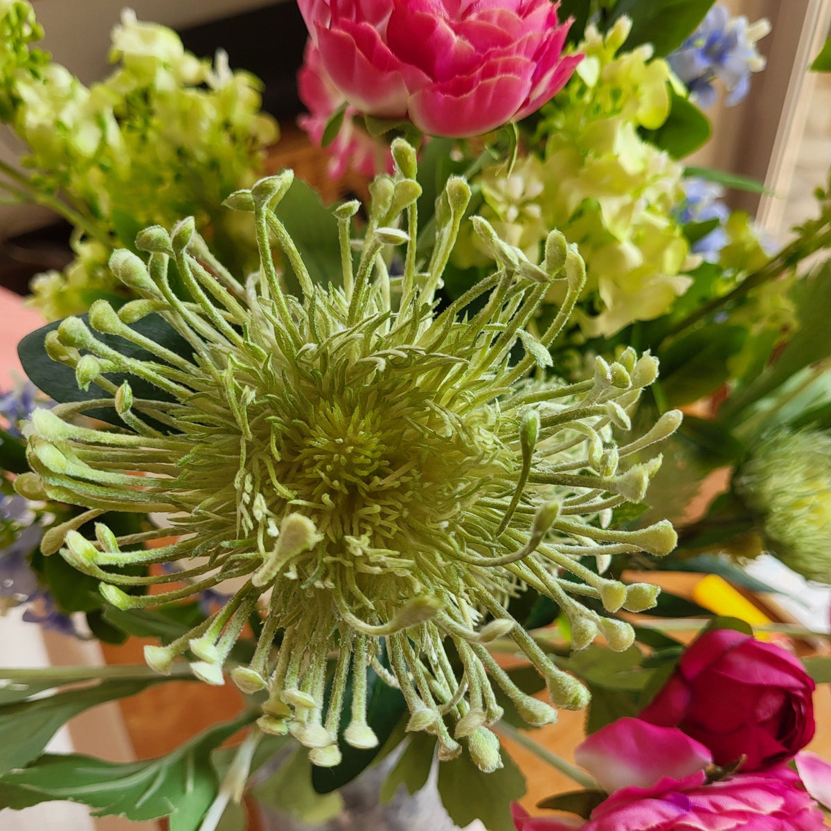 Artificial spider chrysanthemum in a sage green shade, its fine thin petals close to the real flower