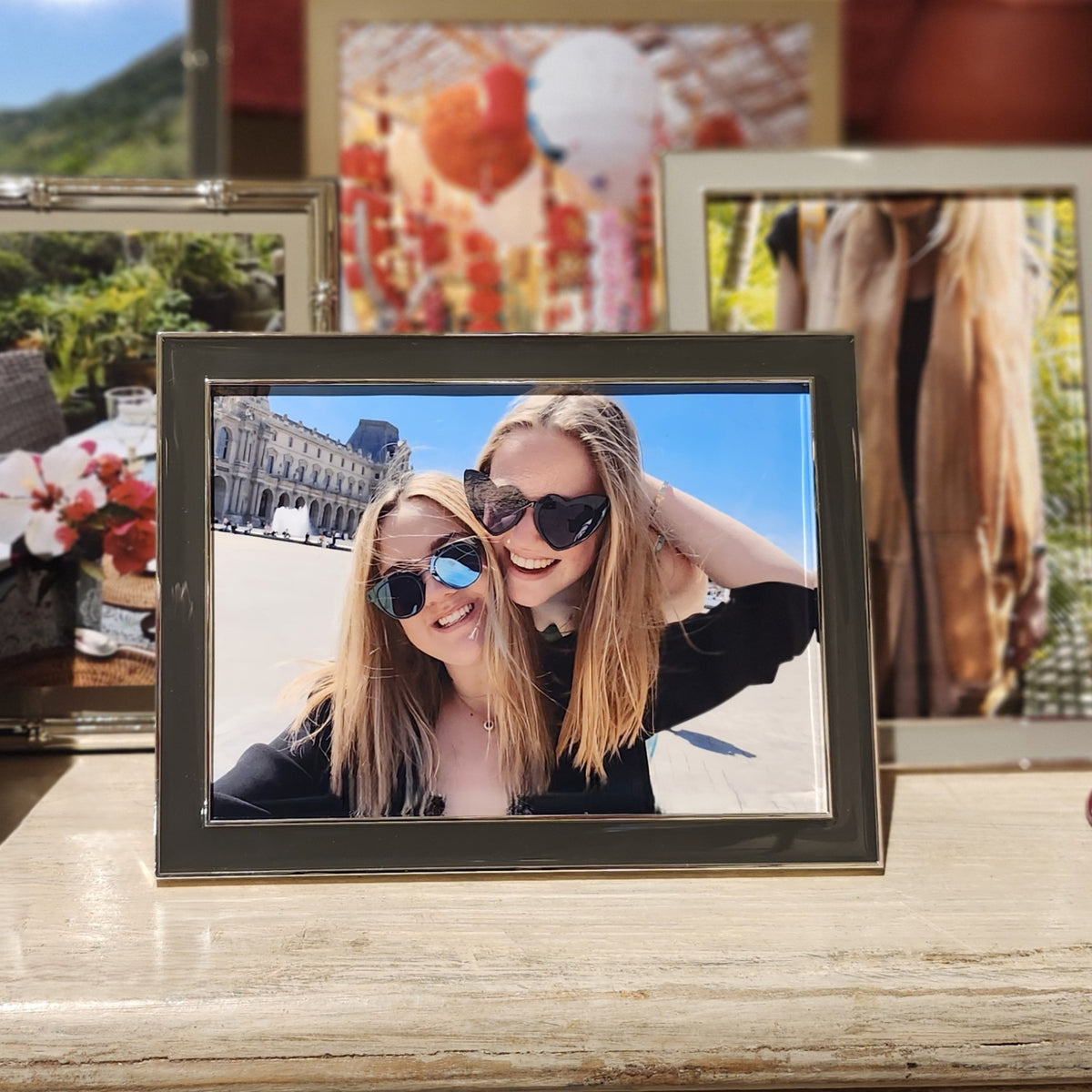 Taupe enamel and silver-plate photo frame by Addison Ross, shown in a room setting