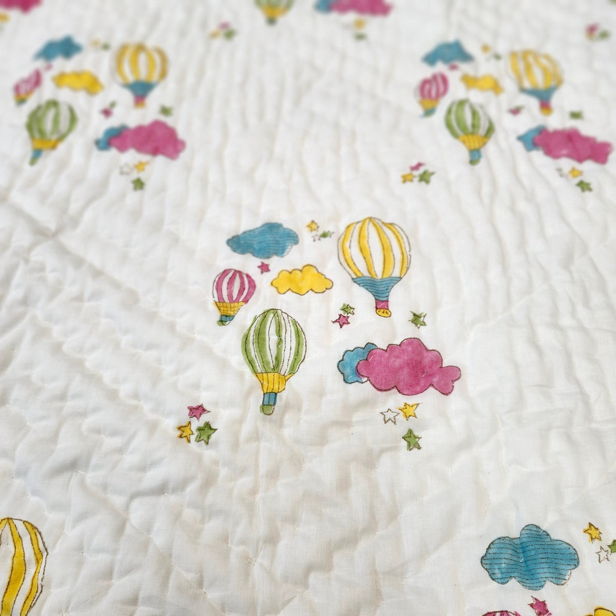 Machine washable child's quilt in fine organic cotton cambric, printed with colourful balloons on one side