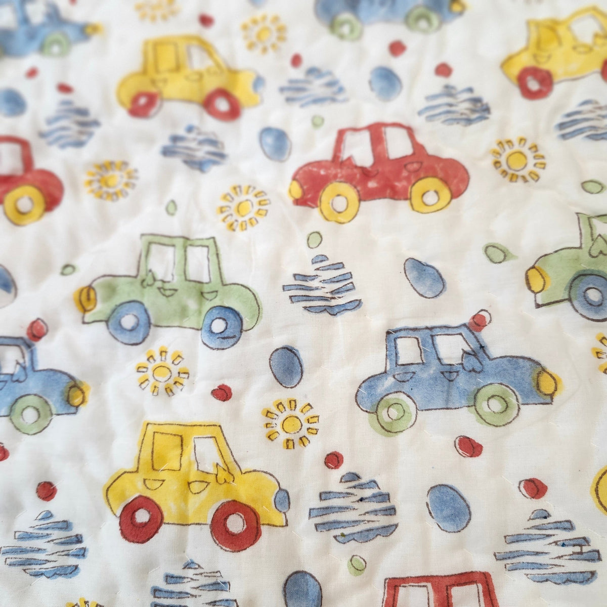 Organic cotton cambric child's quilt, about 102cm x 152cm, printed with colourful cars and reversible to blue trellis