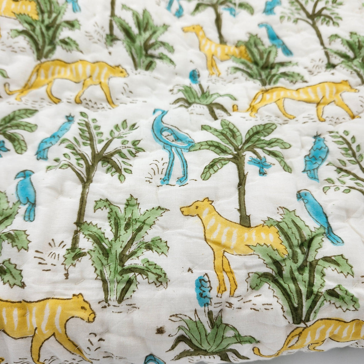 Reversible jungle print child's quilt, with a contrast chevron stripe pattern on the other side to use either way