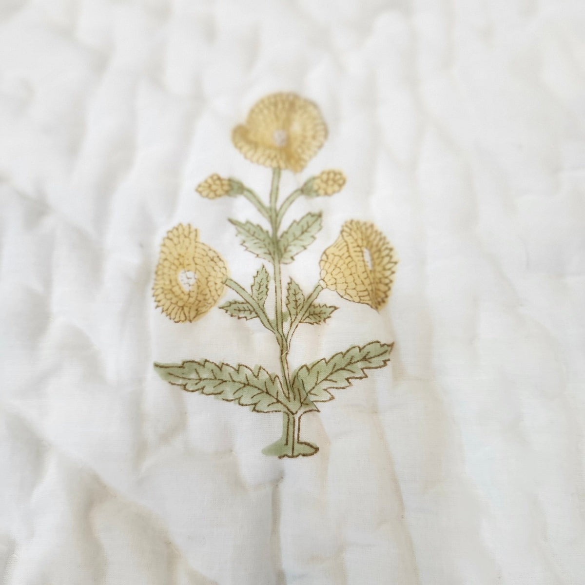 Reversible child's quilt, 40 x 60 inches, with a small marigold print on the reverse of the large yellow flowers