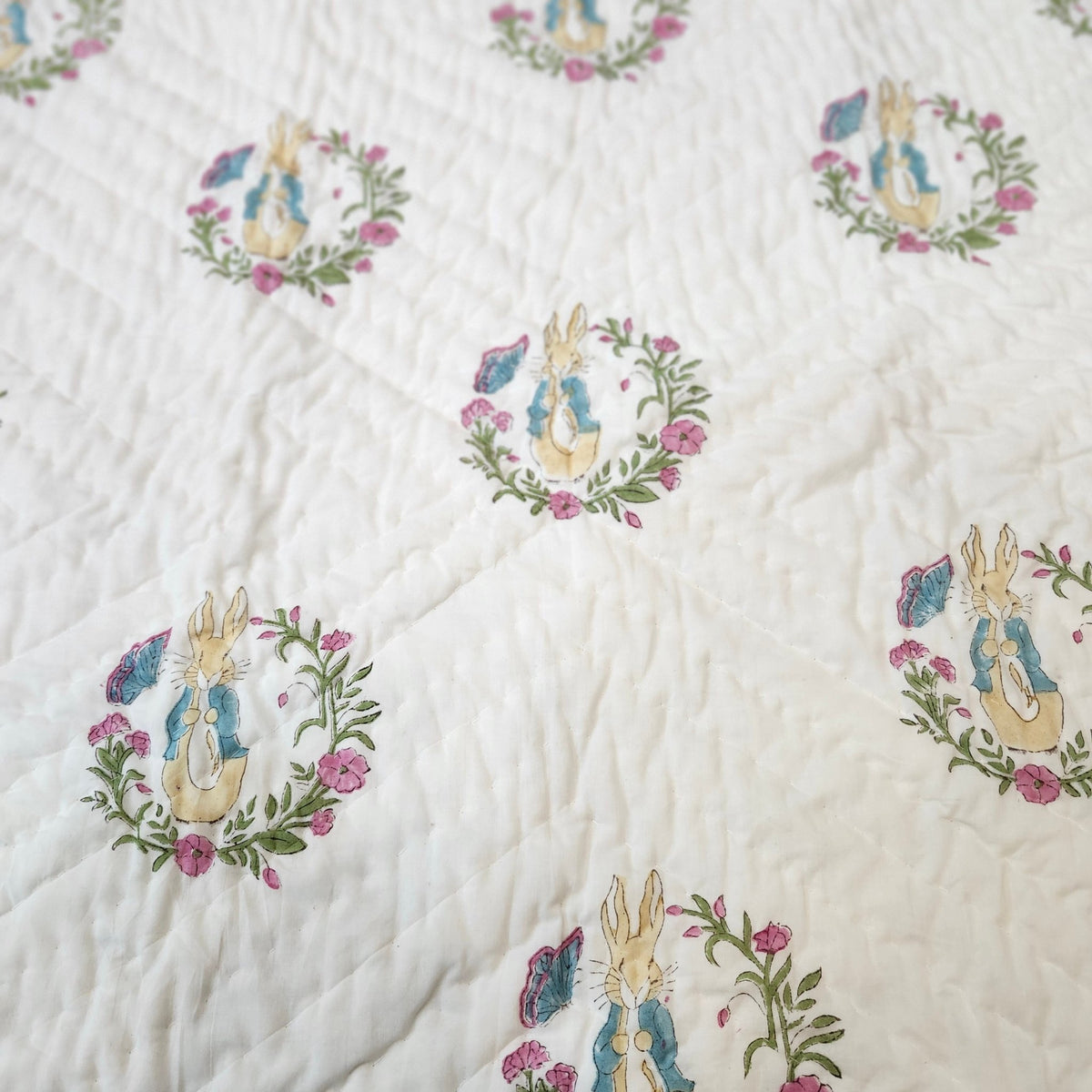 Child's block print quilt with a Peter Rabbit print, made from fine organic cotton cambric and machine washable