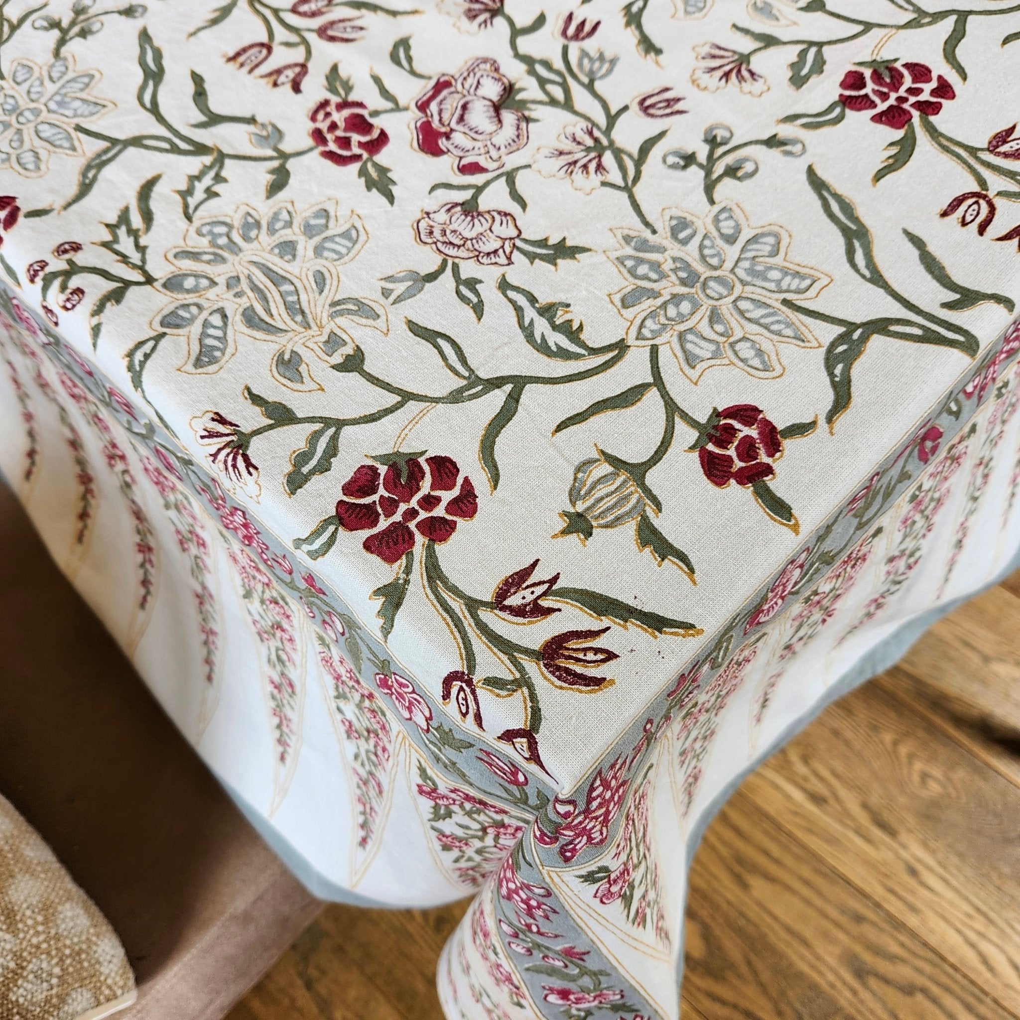 Block printed cotton tablecloth with silver flower print and a wide bordered edge with pennants