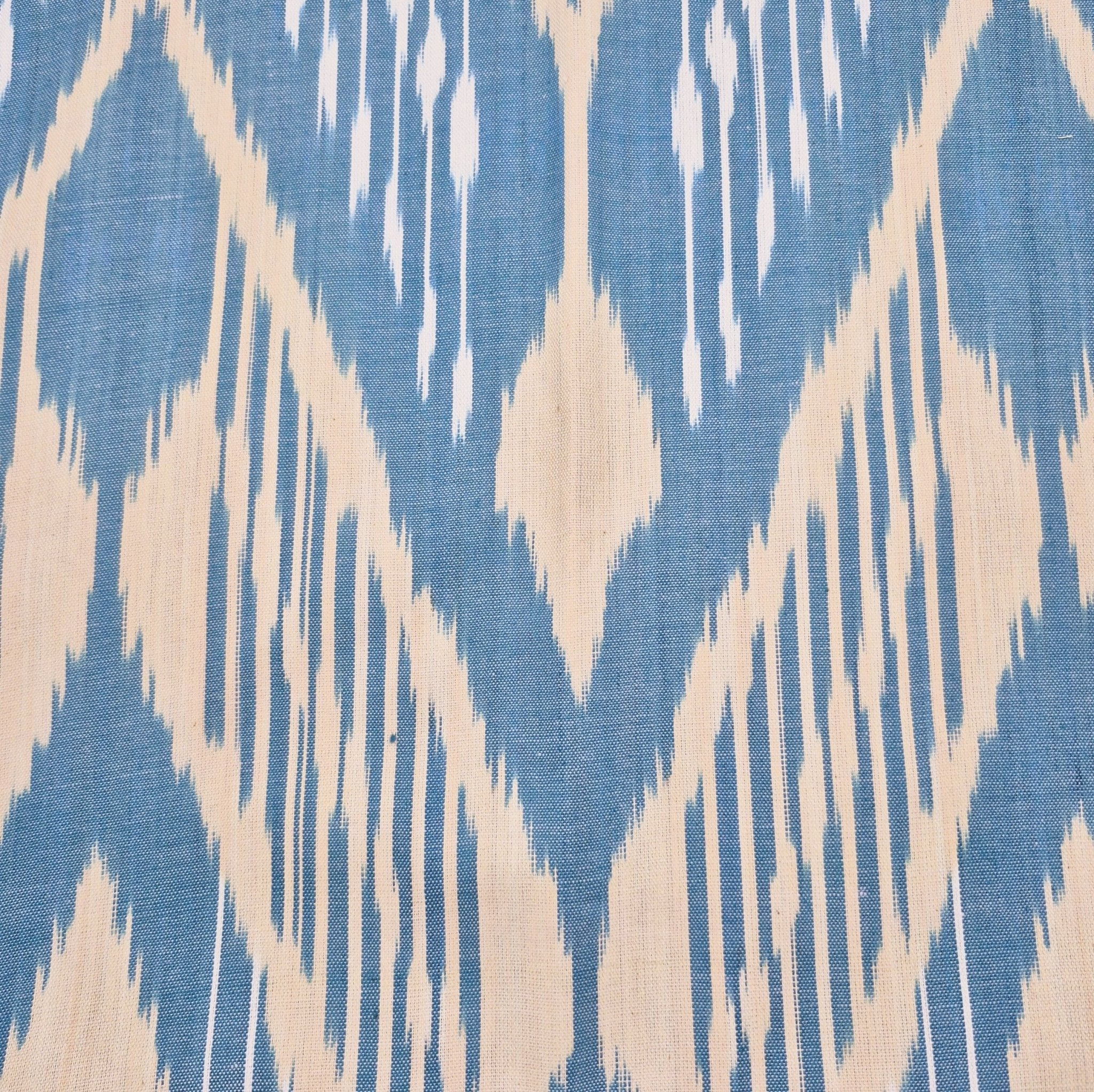 Reverse side of the blue ikat table runner, showing the woven fabric with white thread detail.