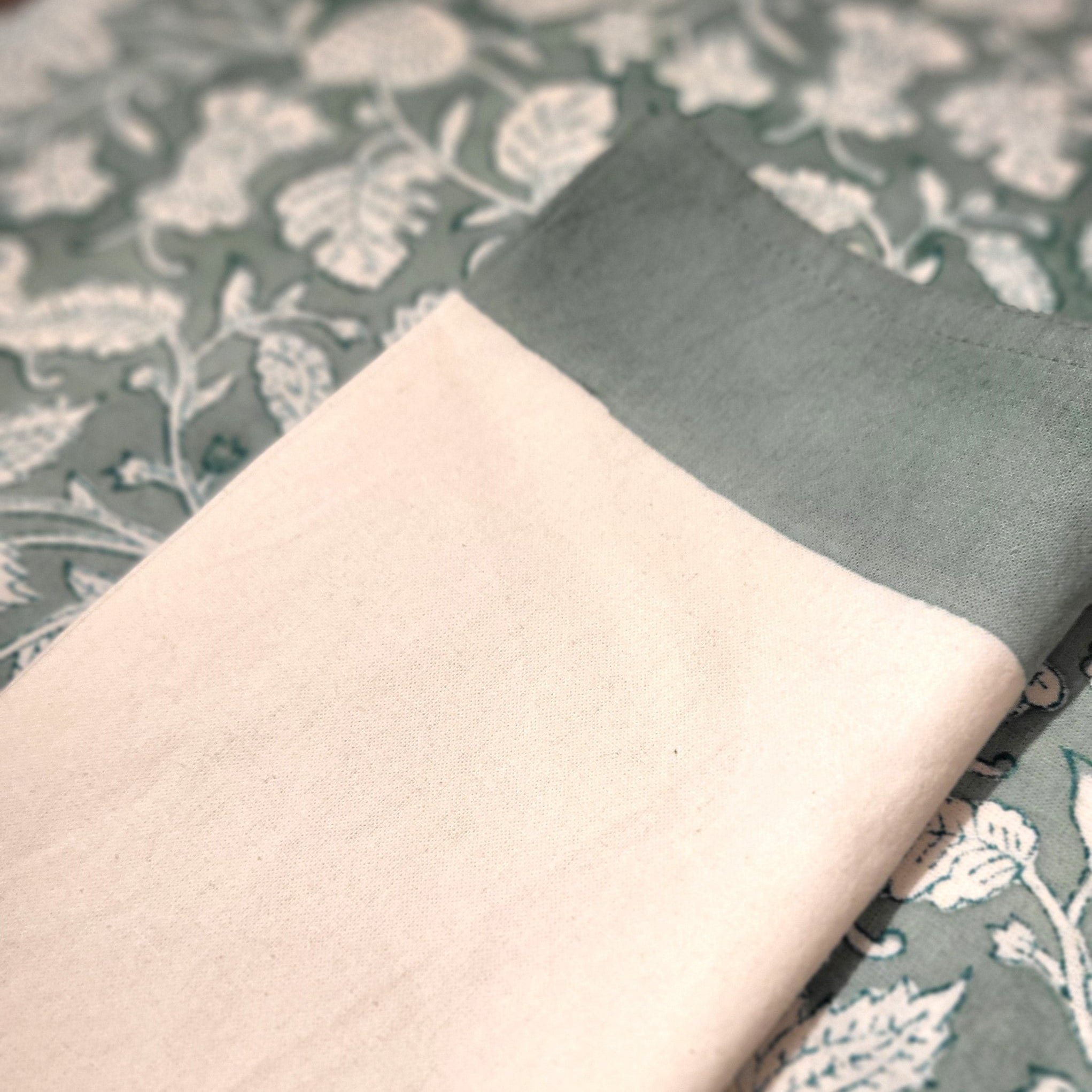 Block print napkin with teal border from Inside Living Singapore, matching the teal floral tablecloth.