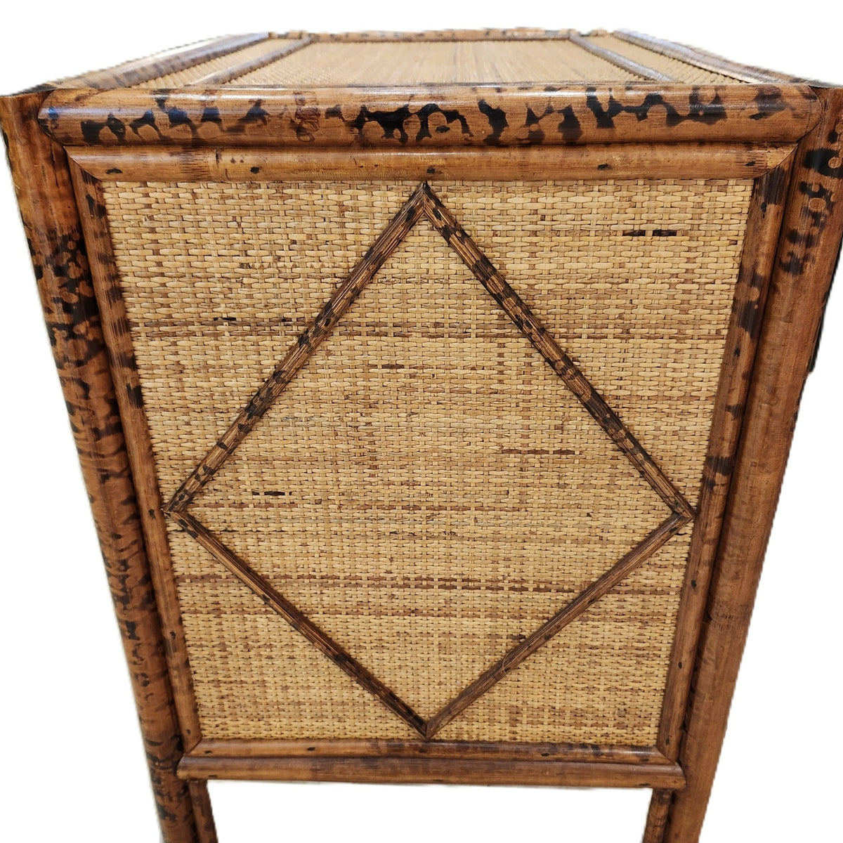 A drawer of the Colonial-style chest pulled open, showing the carved handle and the cane-wrapped frame