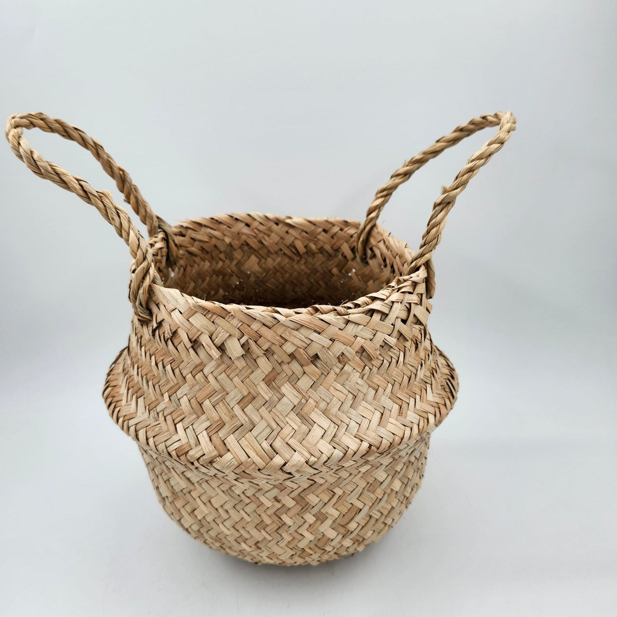Woven seagrass basket with handles that folds into a bowl, 20cm wide by 18cm high, for storage or display