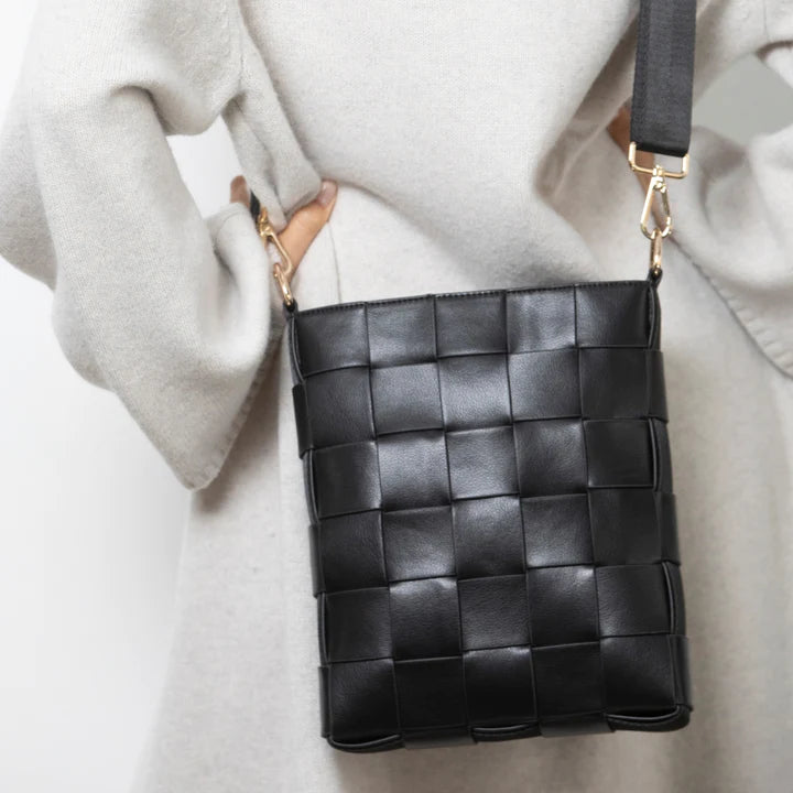 Braided strap bag black shown styled, woven handbag with a braided handle, a chic everyday carry accessory.