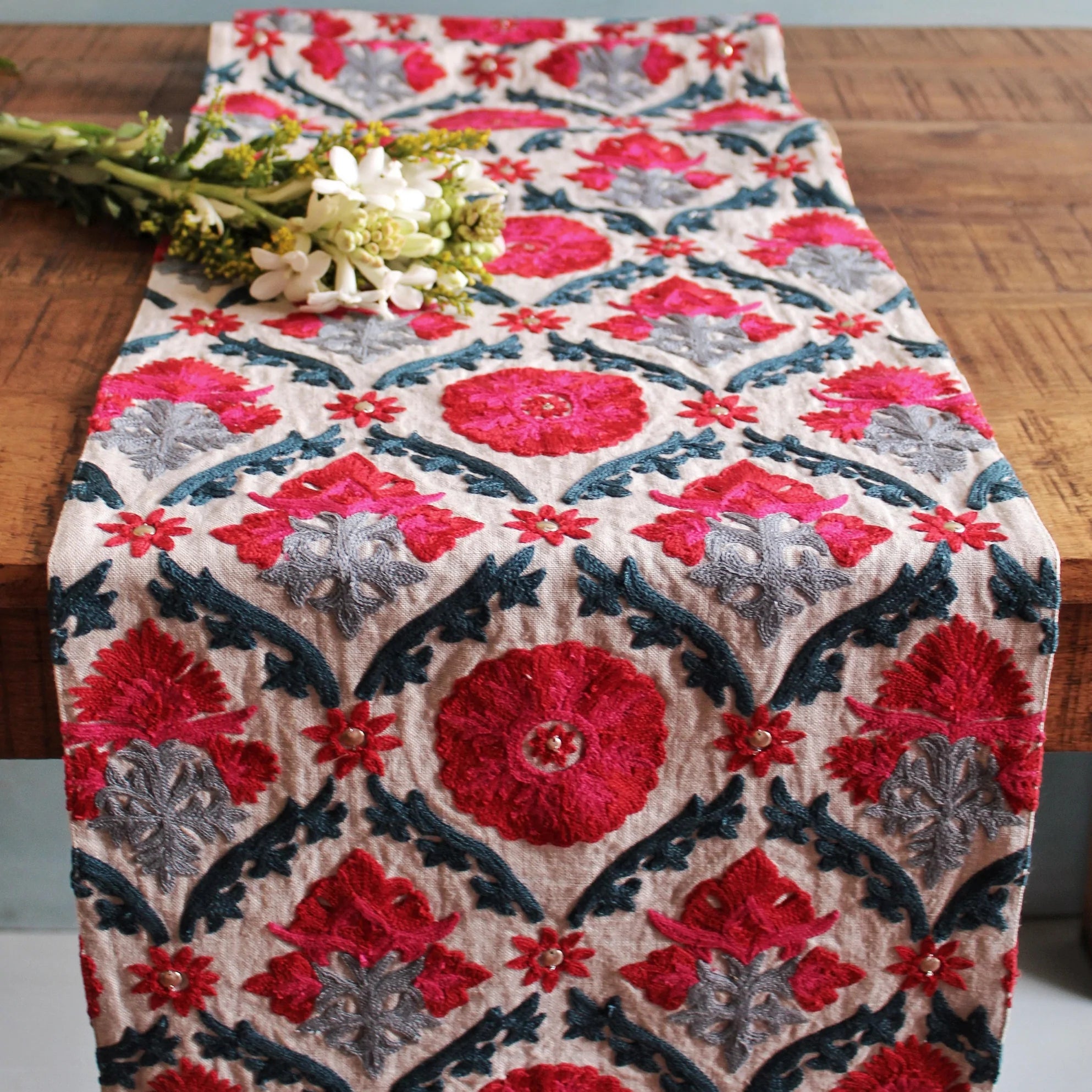 Hand-embroidered linen table runner in red, pink, blue and grey suzani with corner tassels, 183 x 33 cm