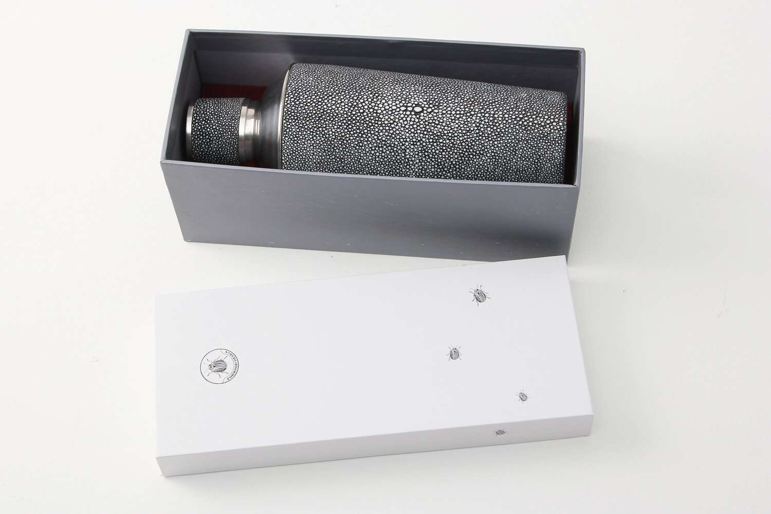 Gift Guide banner showing a charcoal faux shagreen cocktail shaker with polished stainless steel trim.