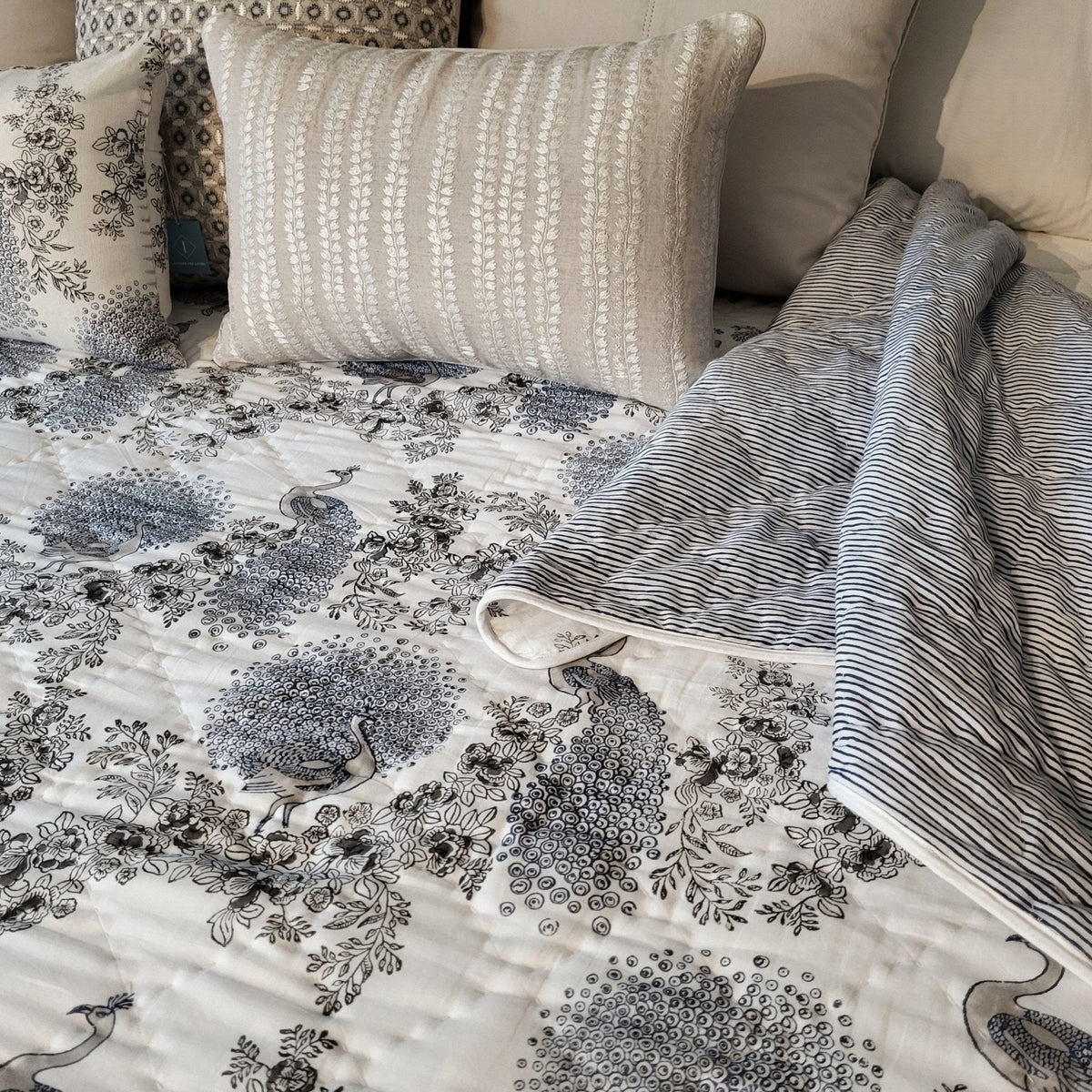 The Samode Peacock quilt, light Jaipur hand quilting in pristine cotton with a coordinating piped edge.