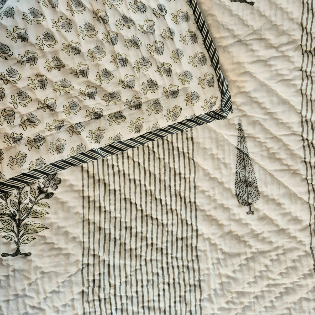 Block print single quilt with a small floral print in the same colours on its reverse, usable either way