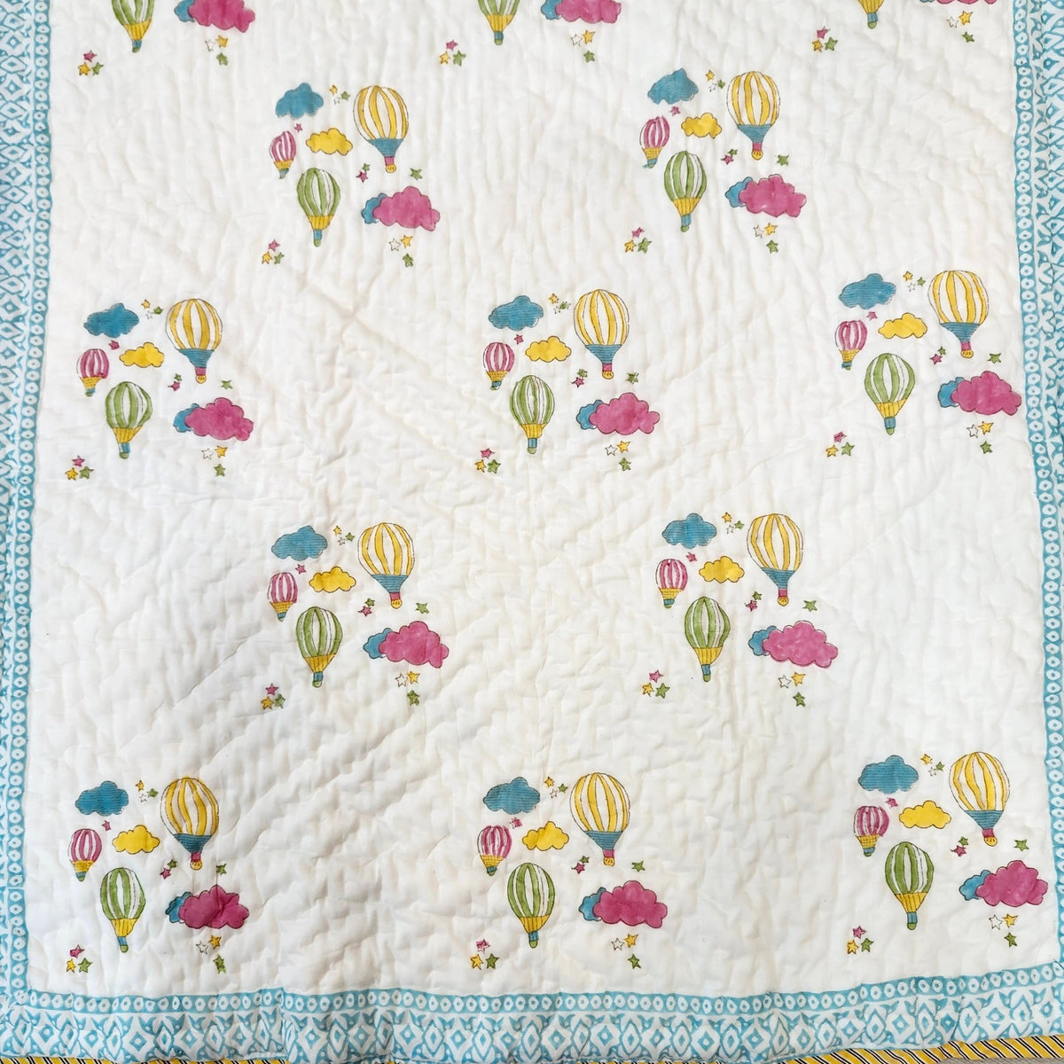Child's block print quilt in organic cotton cambric with a colourful balloon pattern, 40 x 60 inches