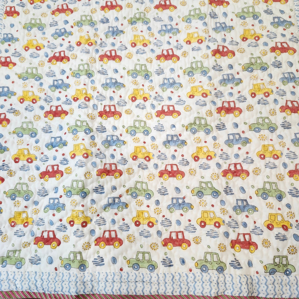 Machine washable car print child's quilt in soft organic cotton cambric, with a blue trellis pattern reverse