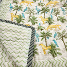Child's block print quilt with a jungle print of yellow big cats and blue birds, in organic cotton cambric