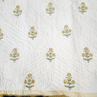 Child's marigold block print quilt in organic cotton cambric, with a large yellow marigold print on one side