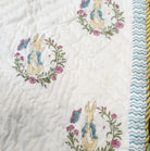 Soft organic cotton cambric quilt for a child, printed with Peter Rabbit on one side and blue spots on the other