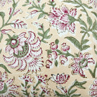 Cushion cover with hand block printed pink flowers and green leaves, suited to white bed linens or a small sofa