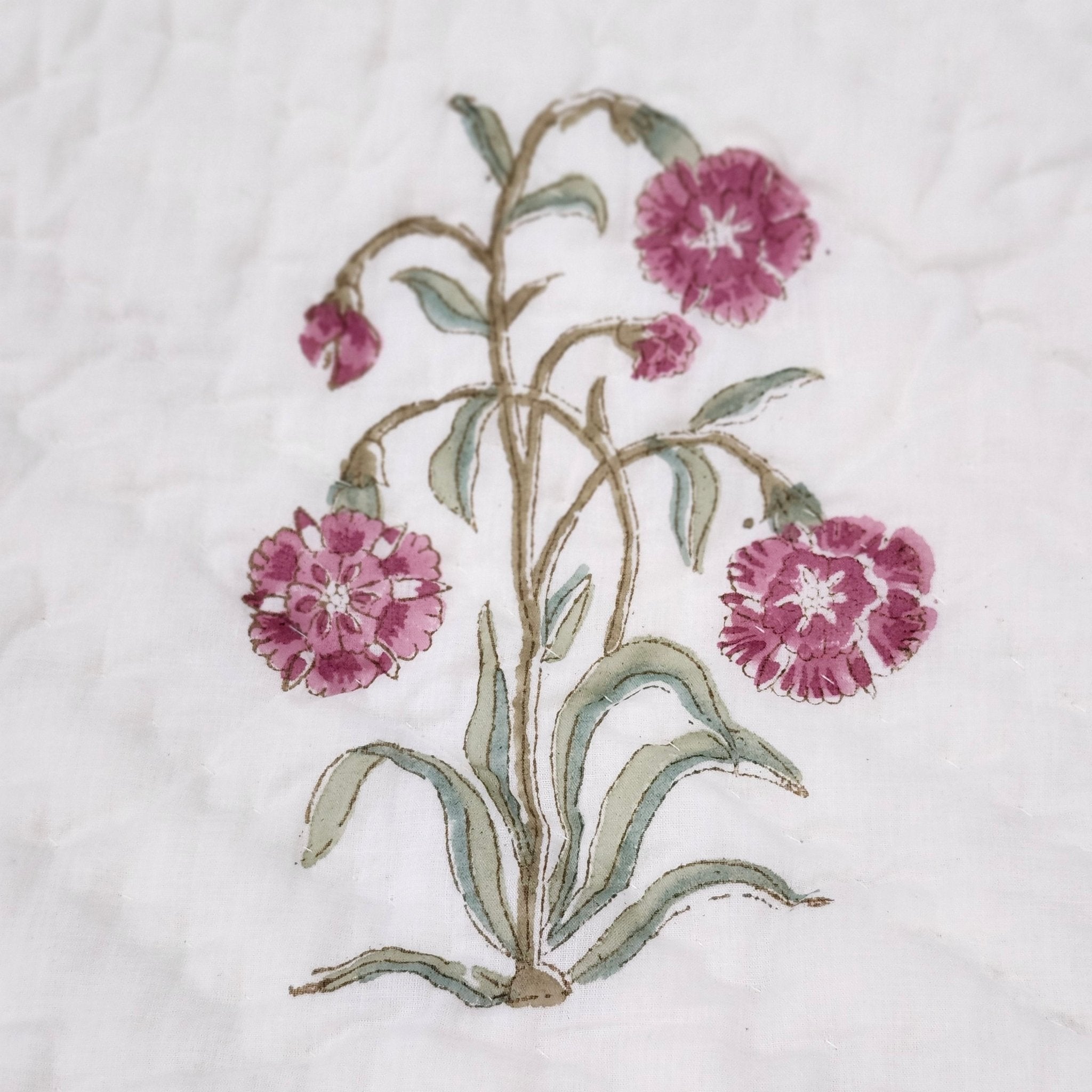 Close-up of the pink carnation block print on this soft, lightweight reversible single cotton quilt.