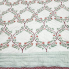 Single quilt hand block printed in a green trellis design on white, with a floral print in matching colours reverse