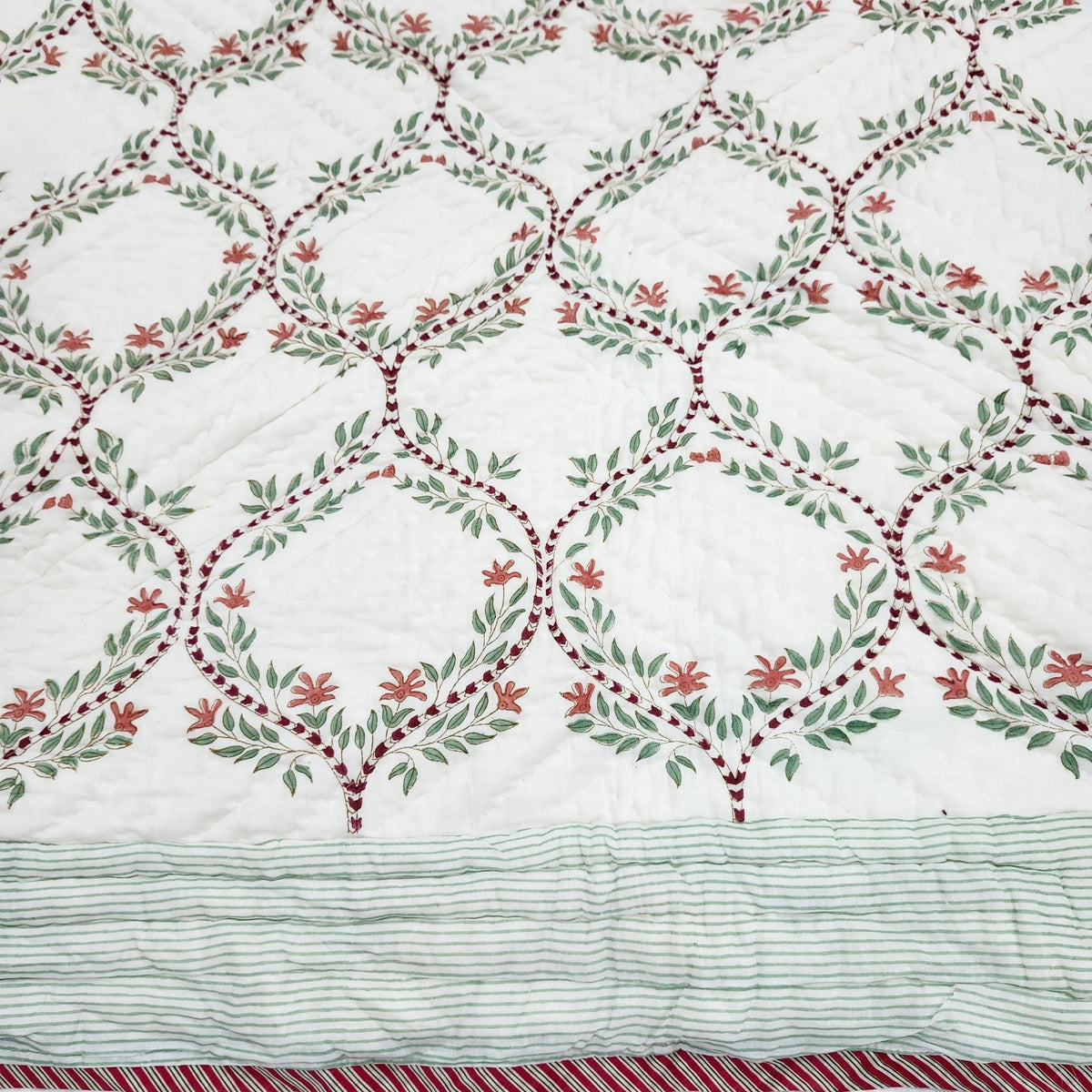 Single quilt hand block printed in a green trellis design on white, with a floral print in matching colours reverse