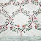 Single size quilt in a green and white trellis block print, each piece slightly different as it is printed by hand