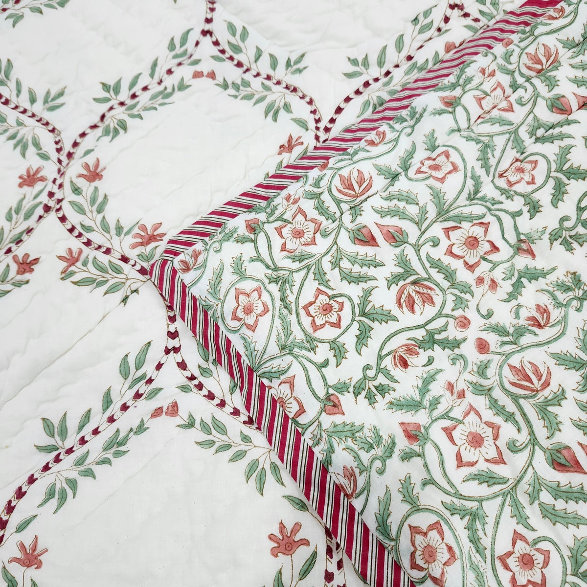 Green trellis block print quilt in a single bed size, with the floral reverse side in the same colours