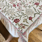 Block printed cotton tablecloth with silver flower print and a wide bordered edge with pennants
