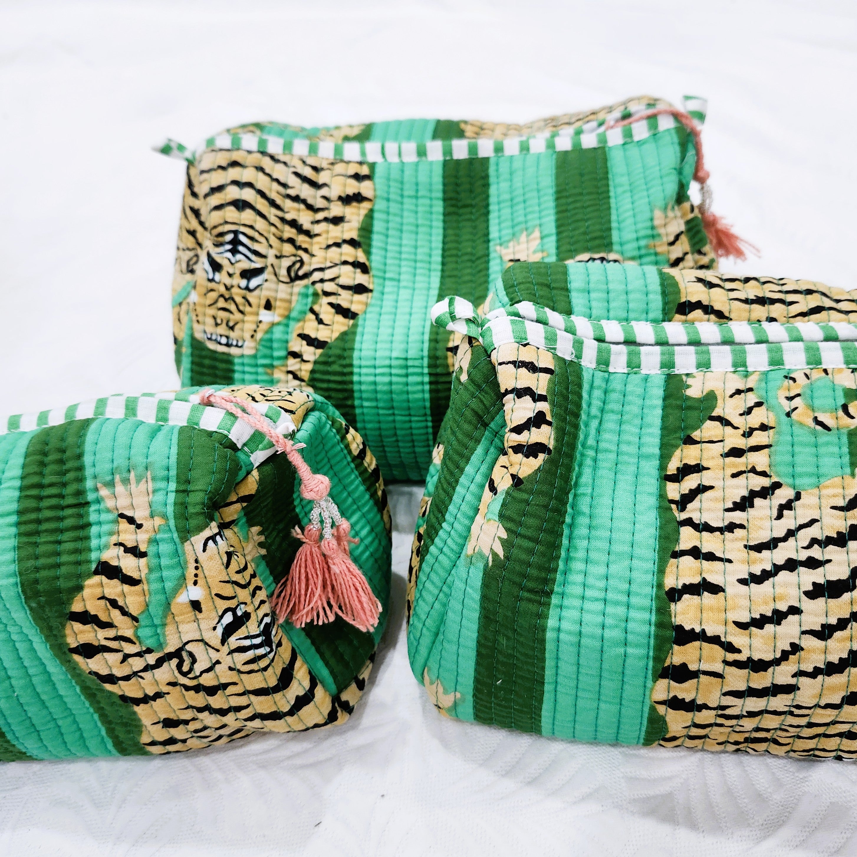 Block-print wash bag in emerald with a tiger and stripe design, lined with four pockets and a zip, in three sizes