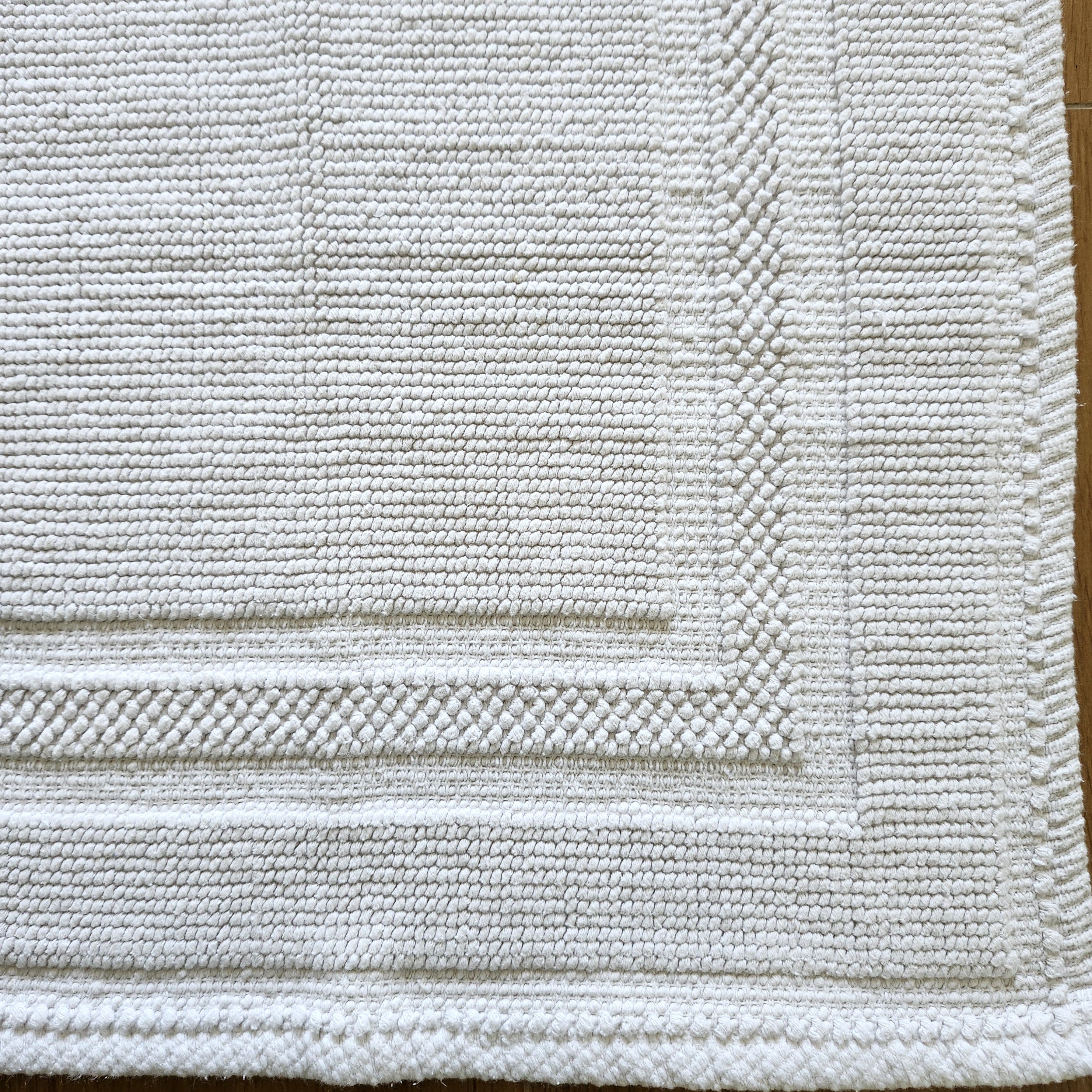 White stonewashed cotton bath mat with looped weave, soft and absorbent, 43 x 60 cm, made in India