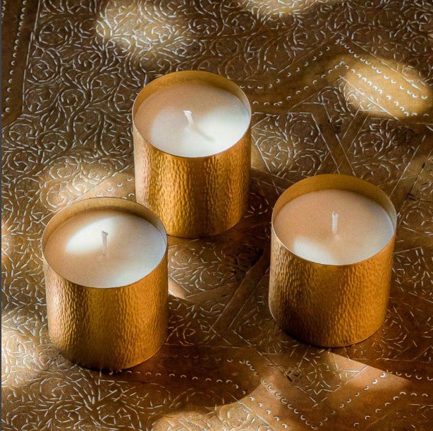 Gift set of three soy travel candles with pine and eucalyptus scents in hammered brass holders