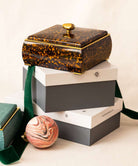 Sophie jewellery box in faux tortoiseshell, 17 x 17 cm, with aubergine lining and a brass pebble knob