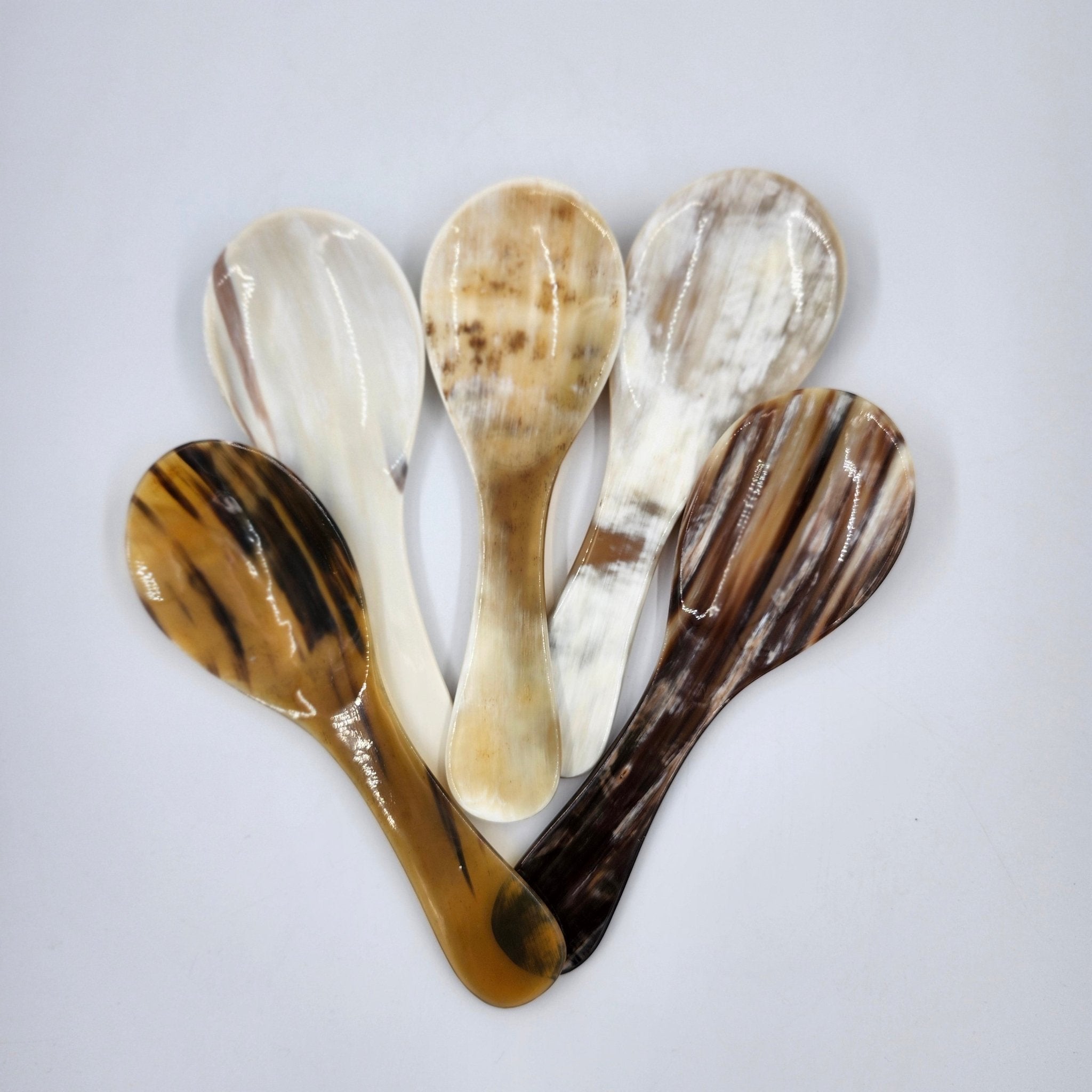 Alternative view of the handcrafted horn flat spoon, showing its wide, shallow, short-handled shape.