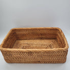 Rectangular handwoven natural rattan basket for home storage of throws, toys and household items, close-up view