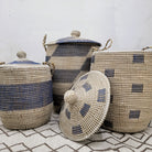 Handwoven seagrass laundry basket with blue detail, handles and a lid, available in three sizes