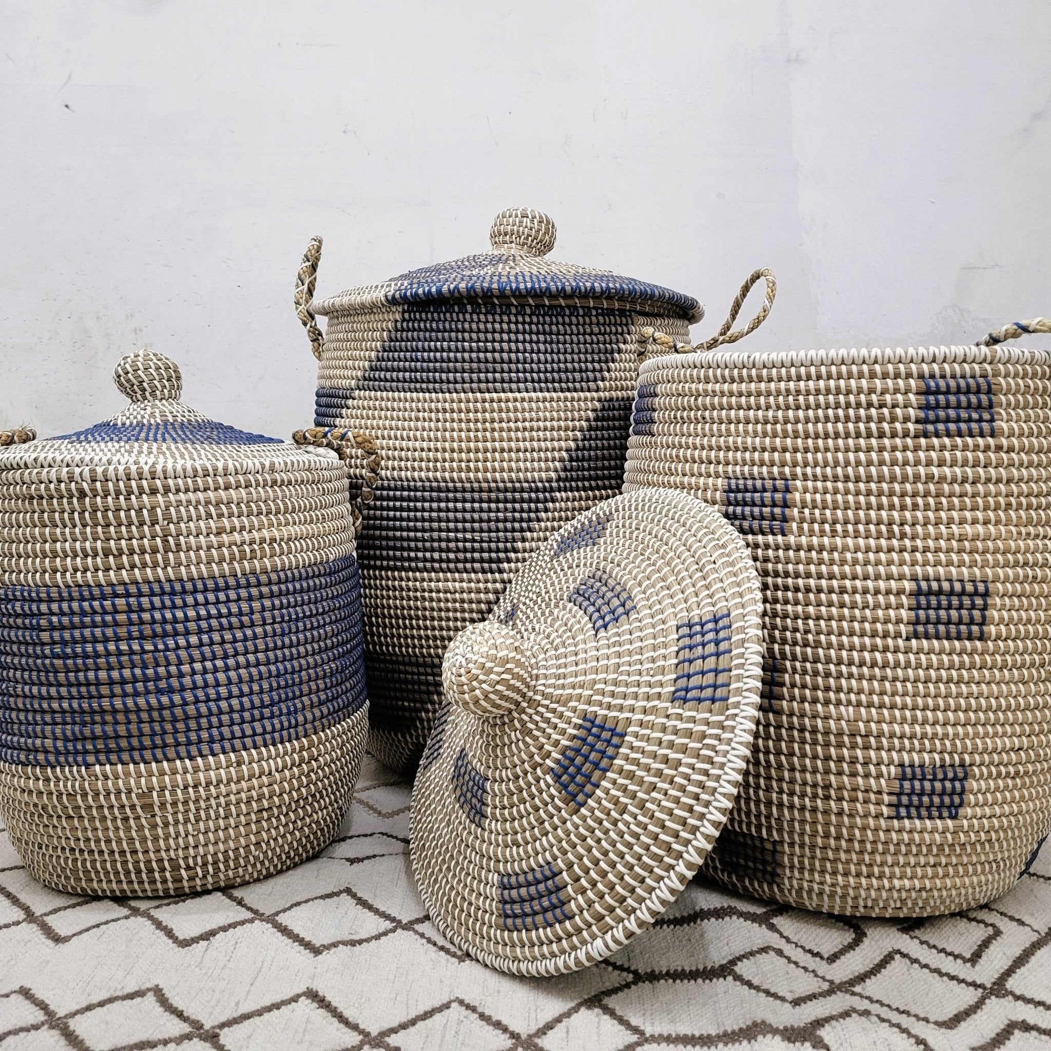 Handwoven seagrass laundry basket with blue detail, handles and a lid, available in three sizes