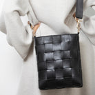 Braided strap bag black shown styled, woven handbag with a braided handle, a chic everyday carry accessory.
