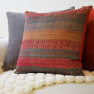Handwoven silk and linen cushion in orange and red, an artisan scatter cushion adding warm colour to seating.