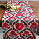 Hand-embroidered linen table runner in red, pink, blue and grey suzani with corner tassels, 183 x 33 cm